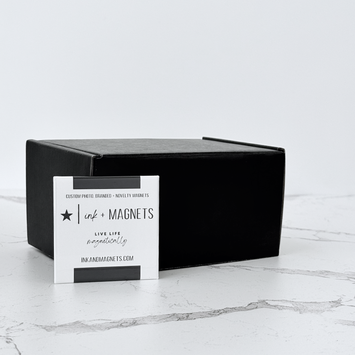Branded promotional button magnet with black shipping box, used for custom photo, branded, and novelty magnet orders.