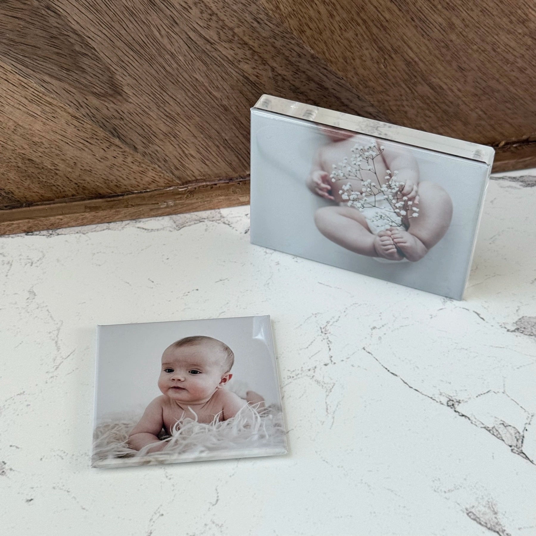 Custom photo magnets showing baby portraits, styled on a surface as a personalized keepsake and thoughtful gift idea
