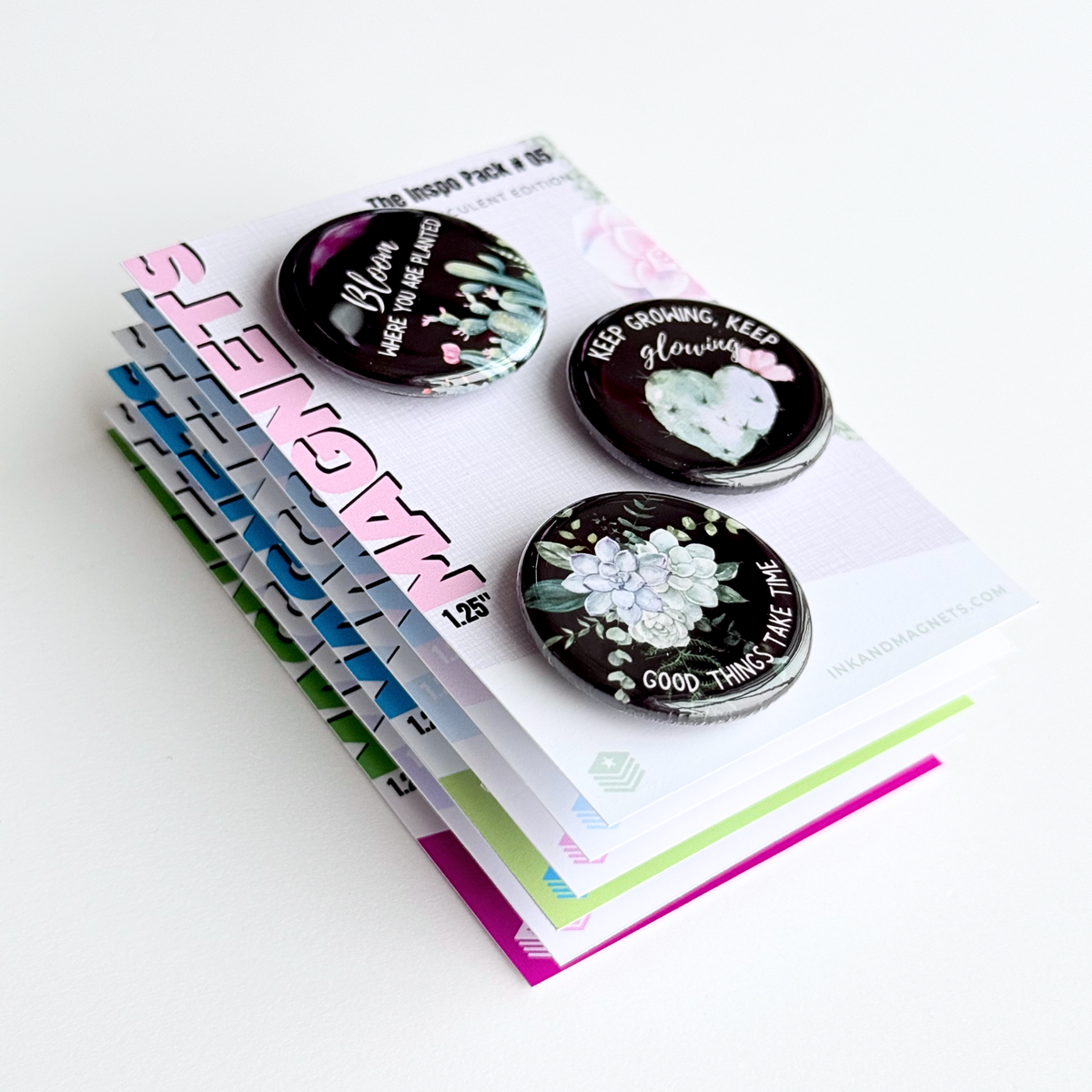 Round button magnets featuring matching succulent designs with motivational messages on a black background.