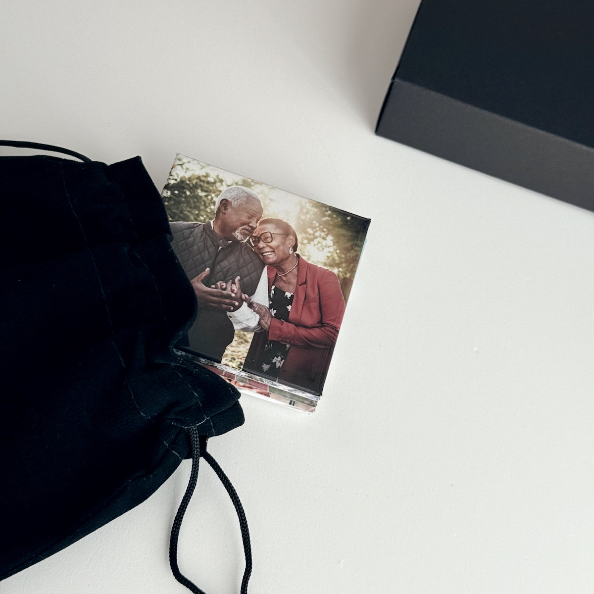 Custom photo magnets being displayed with gift ready black kraft box and gift bag options. Featuring a beautifully captured photograph of a happy older couple enjoying the moment. Making this a perfect gift and daily reminder to cherish your memories and the important people in your life.