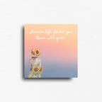 Fridge magnet with a woman holding sunflowers and text 'wherever life plants you, bloom with grace' on a gradient background.
