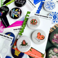 Assorted button magnet packs with novelty designs, including cannabis themed magnets, shown as a colorful fridge magnet collection