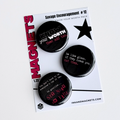 Set of three black button style fridge magnets with motivational phrases on an ink and magnets branded retail card. 