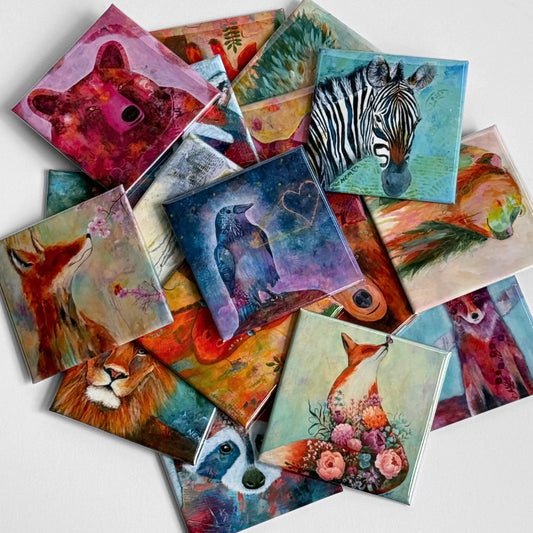 A collection of vibrant art magnets by a local artist featuring colorful animal illustrations on 2.5" square button magnets. 
