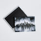 Custom magnets for original artwork featuring a black and white city skyline watercolor painting, shown with the full magnetic back of a rectangular hard-back magnet.
