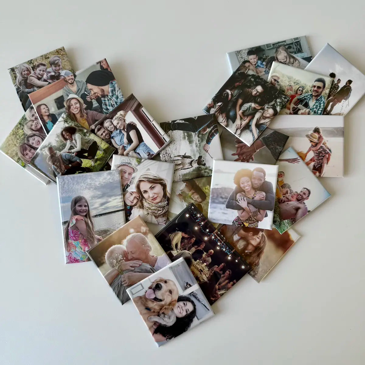 Custom photo magnets arranged in a heart shape on a white surface, showcasing diverse family memories, perfect for personalized fridge decor and meaningful gifts.