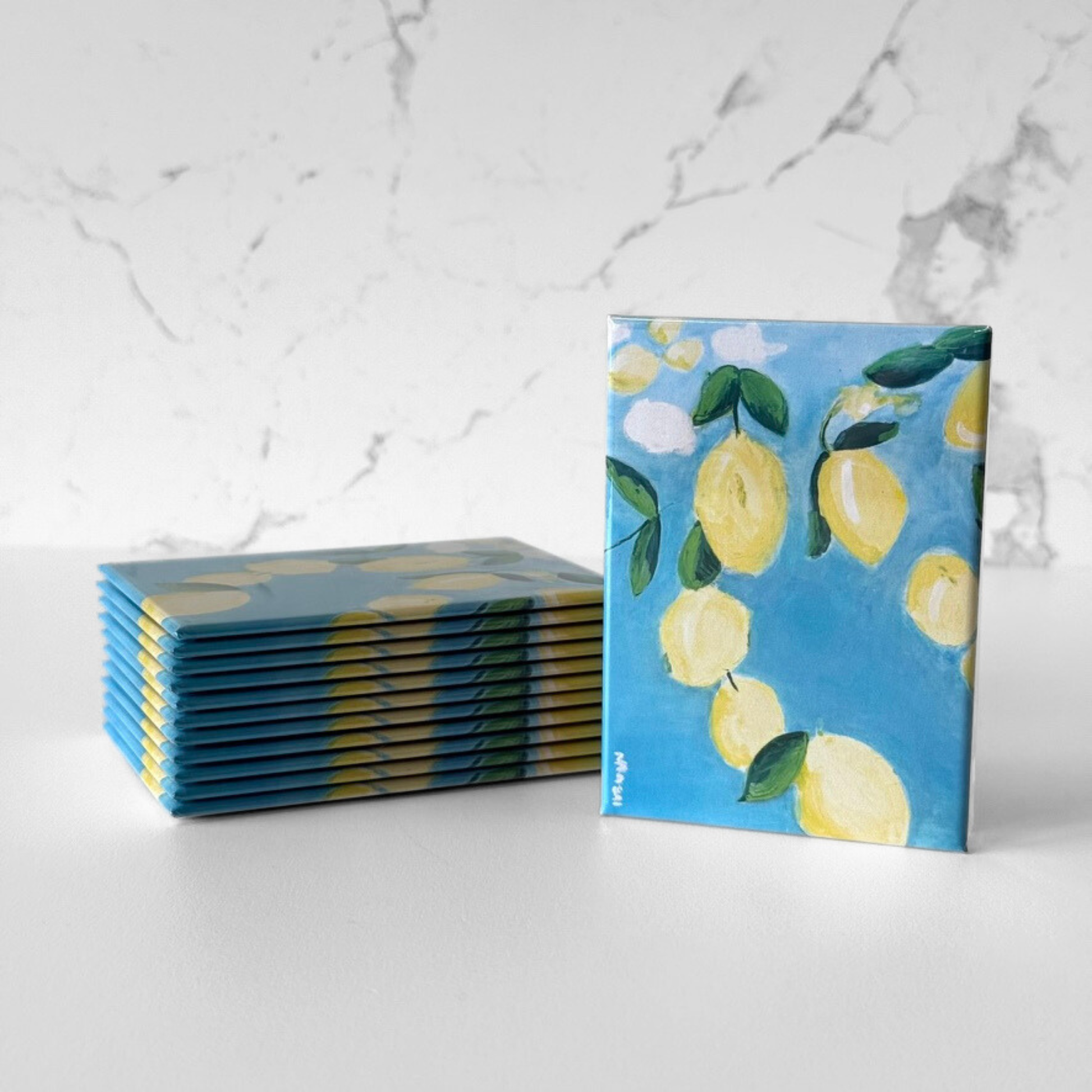 Mini magnetic art prints with lemon artwork displayed as button magnets, shown as a stacked set for retail, gifting, or artist merchandise