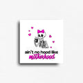 Novelty fridge magnet reads, "Aint no hood like Motherhood," showcasing a skeleton with a pink bow and hearts, holding a coffee. Savage truths about motherhood, meant to make you laugh.