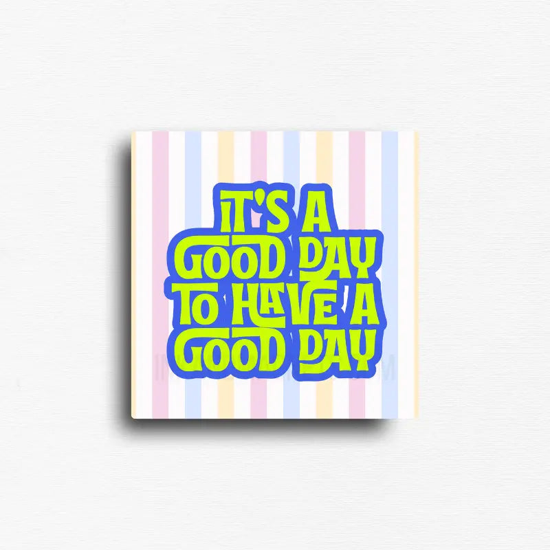 Square positive quote magnet featuring colorful retro lettering on a pastel striped background with the message, "It's a good day to have a good day." A cheerful inspirational magnet for refrigerators, office file cabinets, lockers, classrooms, and magnetic boards.
