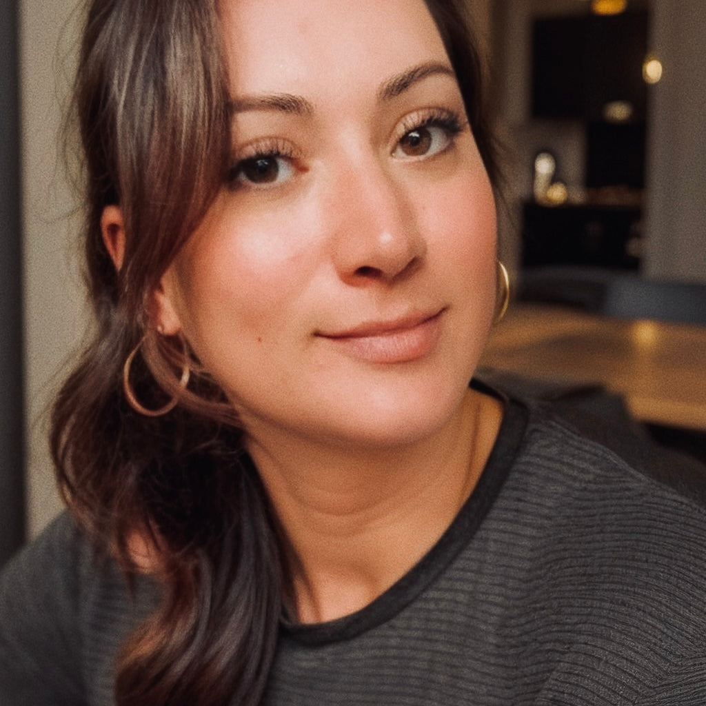 Photo of the female owner and founder of Ink and Magnets. Marli has brown hair and brown eyes, has her hair in a ponytail and is pictured in a casual setting. She is ready to help you place your order. 
