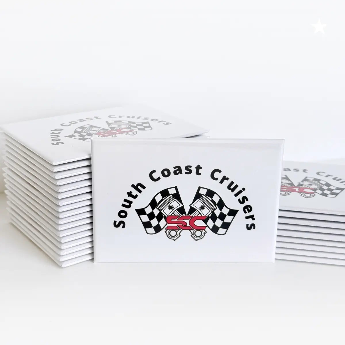 Promotional button magnets made with the South Coast Cruisers logo featuring pistons and race flags. A local car club organization located on the south shore, Massachusetts. 