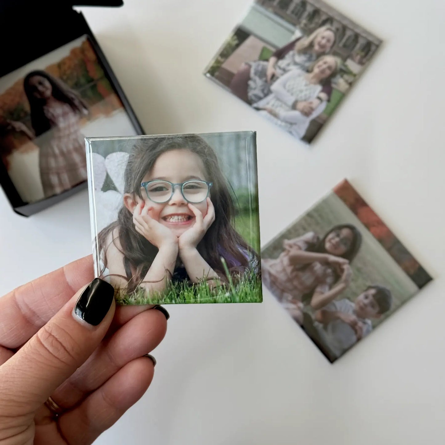 Custom photo magnets for fridge being prepared in a gift ready black box perfect for special occasions, birthdays, and holidays.