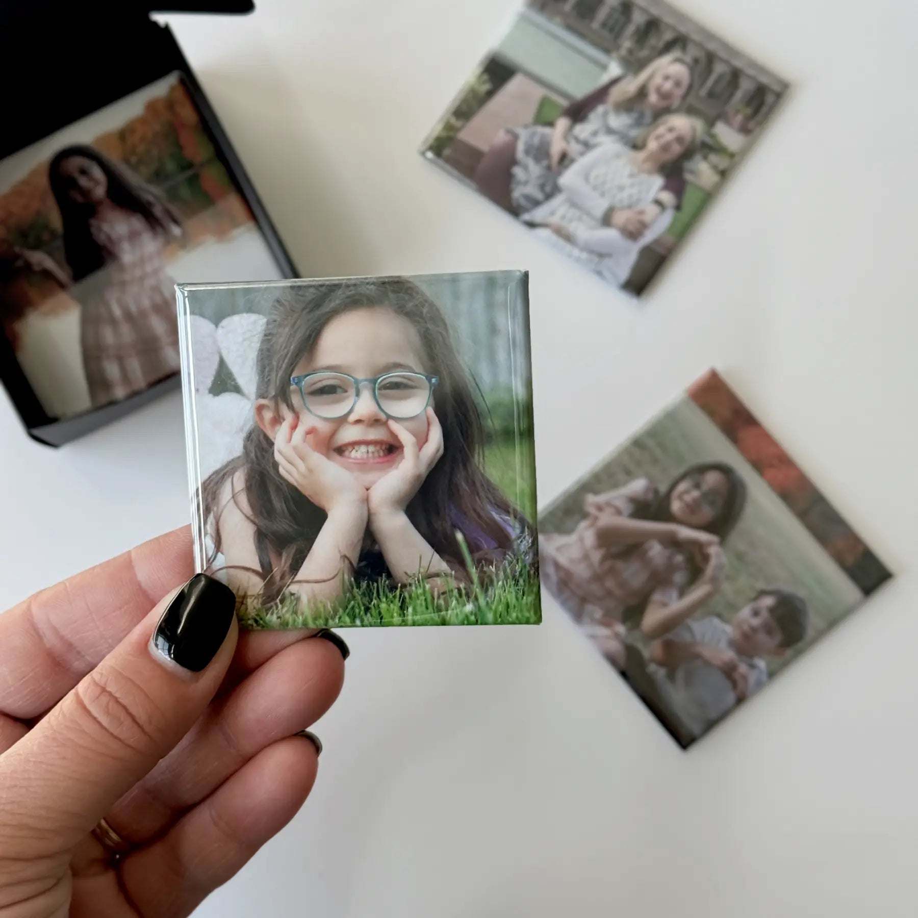 Custom photo magnets for fridge being prepared in a gift ready black box perfect for special occasions, birthdays, and holidays.