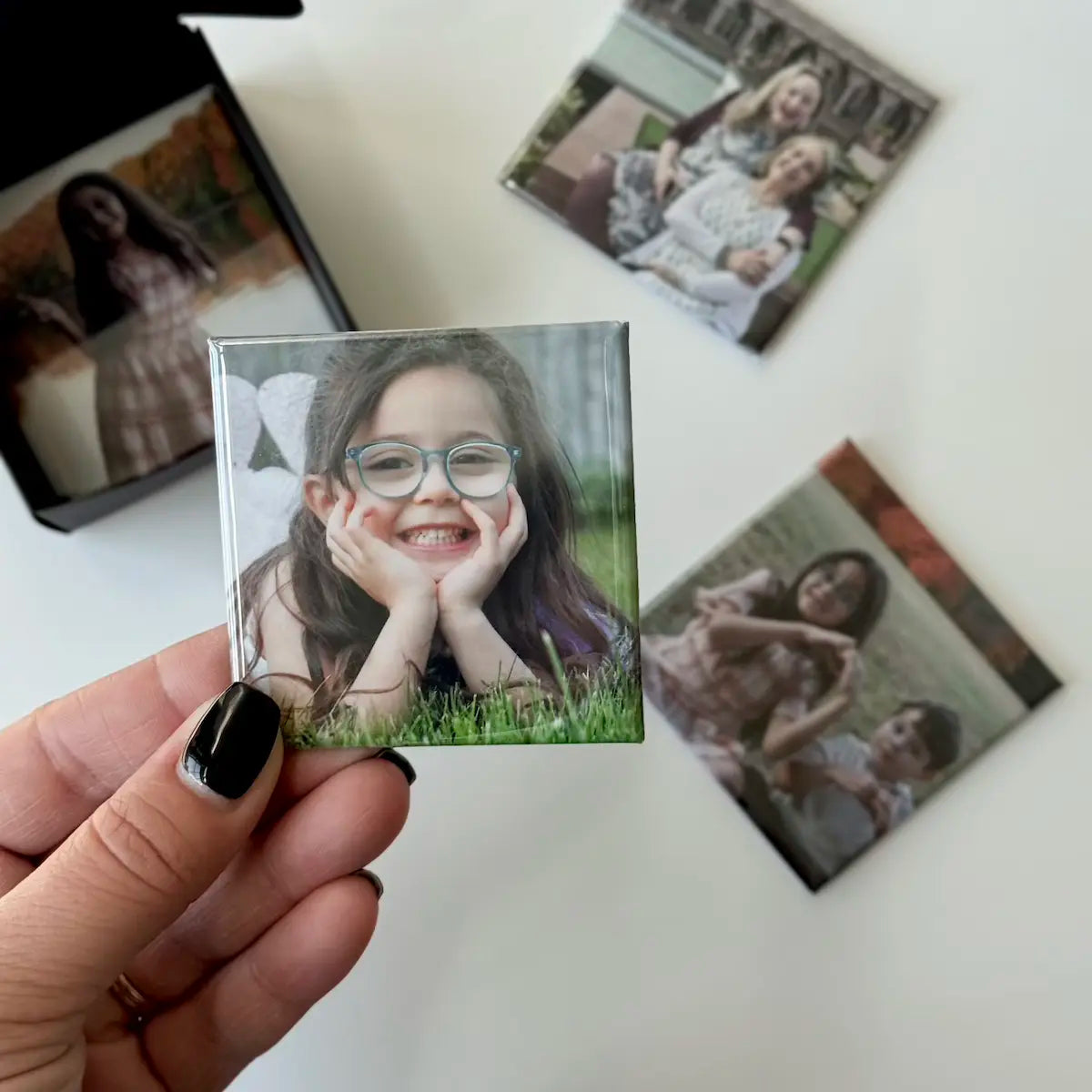 Custom photo magnets for fridge being prepared in a gift ready black box perfect for special occasions, birthdays, and holidays.