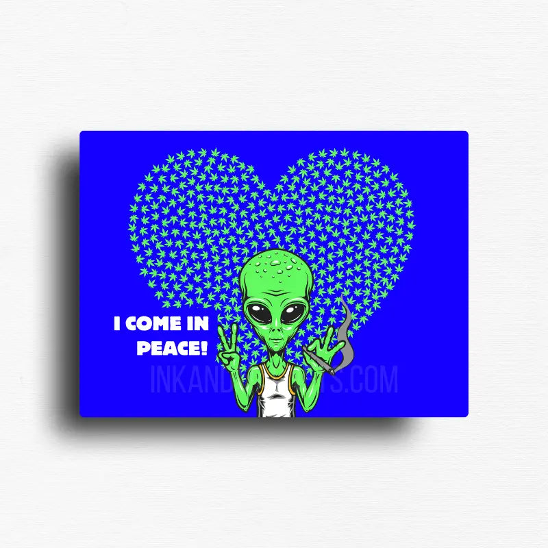 Funny cannabis novelty fridge magnet with green alien with 'I Come in Peace!' text against a blue background with a heart shaped weed leaf pattern. Designed by Ink and Magnets.